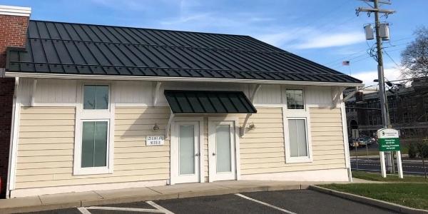 What causes snow to buckle on a metal roof?